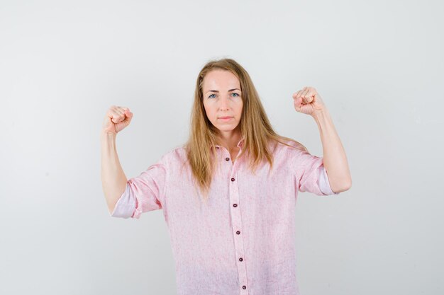 Joven mujer rubia con una camisa rosa casual