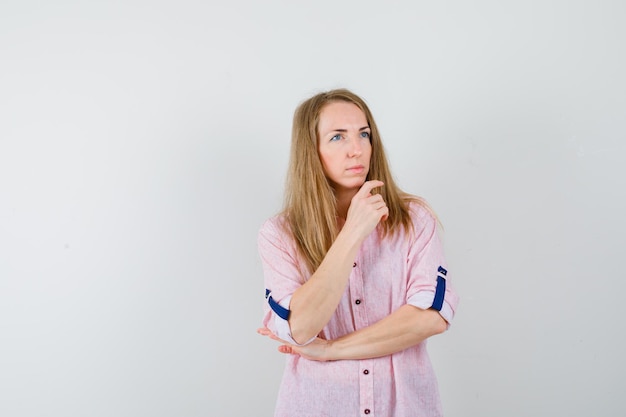 Joven mujer rubia con una camisa rosa casual