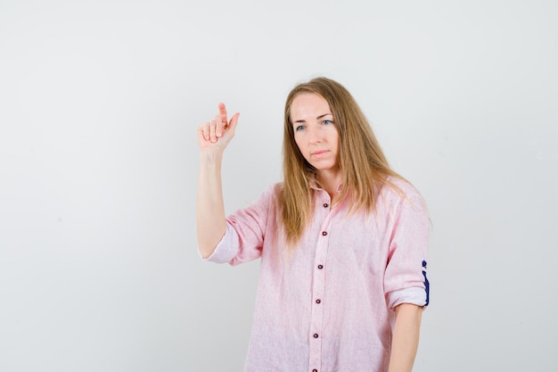 Joven mujer rubia con una camisa rosa casual