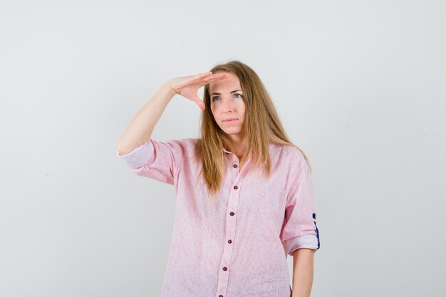 Joven mujer rubia con una camisa rosa casual