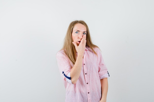 Joven mujer rubia con una camisa rosa casual