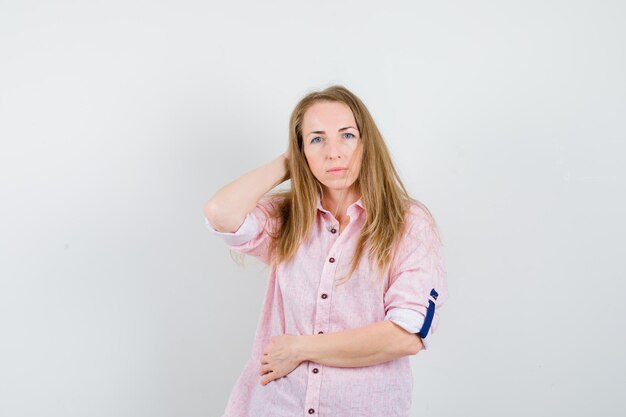 Joven mujer rubia con una camisa rosa casual