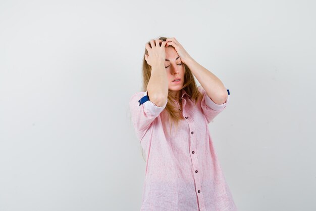 Joven mujer rubia con una camisa rosa casual