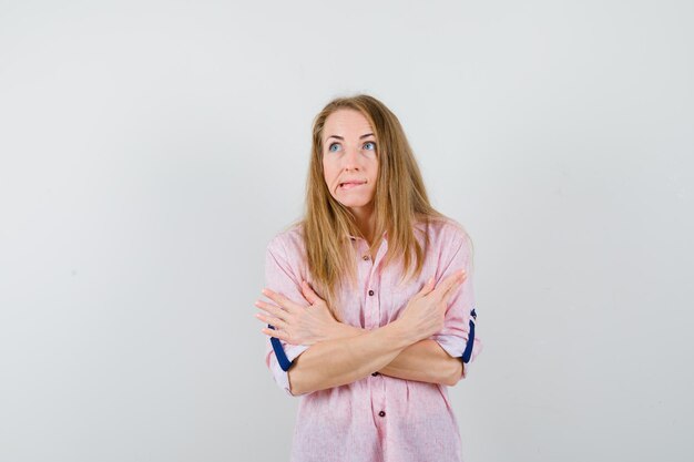 Joven mujer rubia con una camisa rosa casual