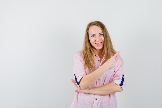 Joven mujer rubia con una camisa rosa casual