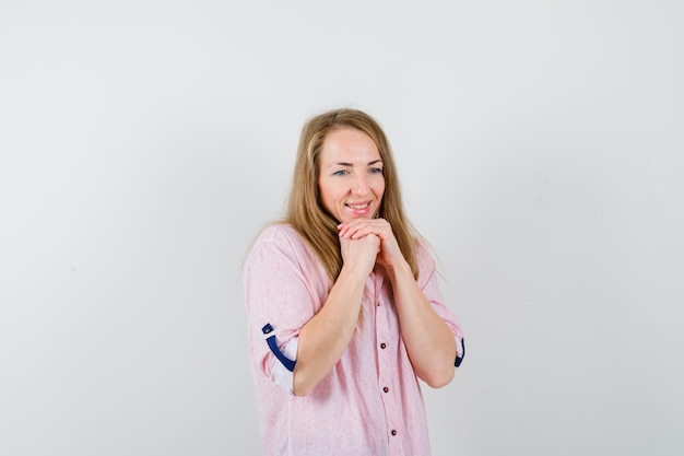 Joven mujer rubia con una camisa rosa casual