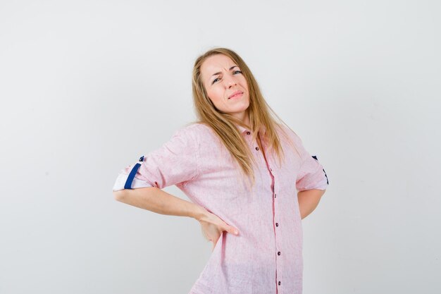 Joven mujer rubia con una camisa rosa casual