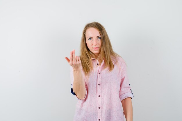 Joven mujer rubia con una camisa rosa casual