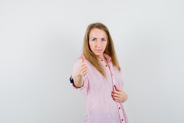 Joven mujer rubia con una camisa rosa casual