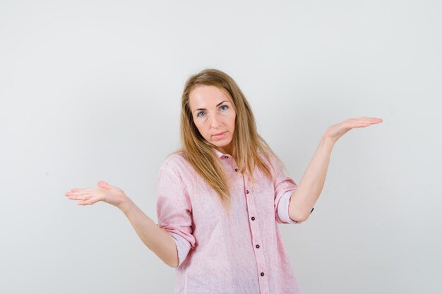 Joven mujer rubia con una camisa rosa casual