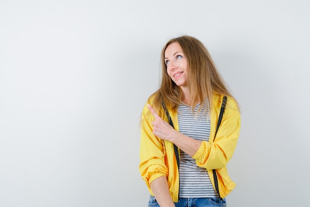 Foto gratuita joven mujer rubia con una chaqueta amarilla
