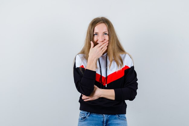 Joven mujer rubia en una chaqueta y jeans