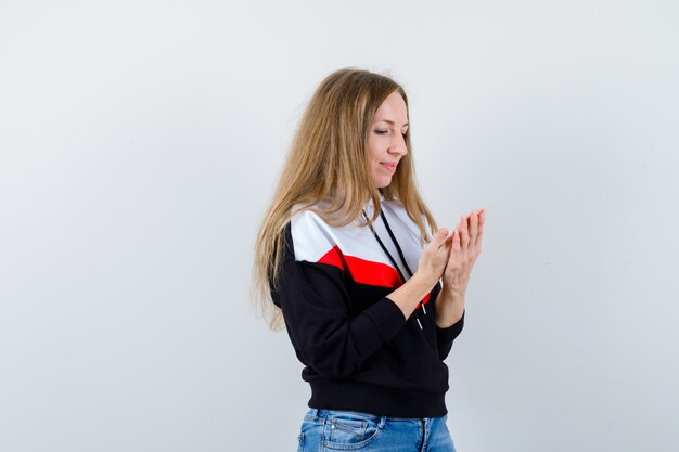 Joven mujer rubia en una chaqueta y jeans