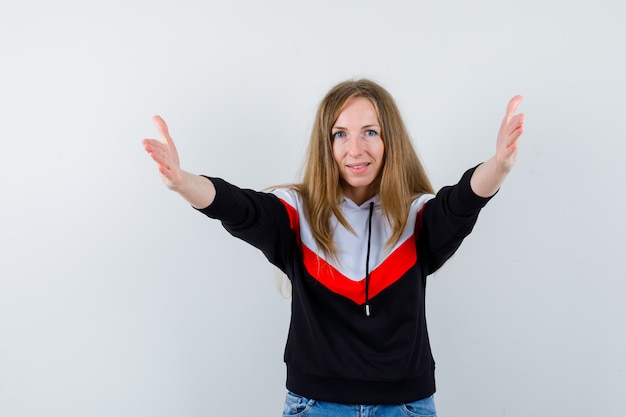 Joven mujer rubia en una chaqueta y jeans