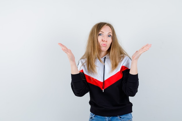 Joven mujer rubia en una chaqueta y jeans