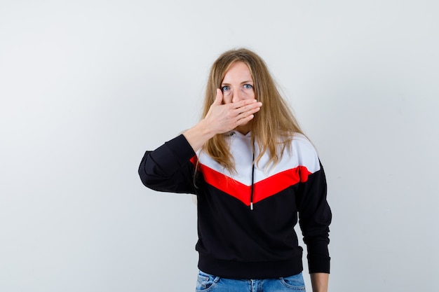 Joven mujer rubia en una chaqueta y jeans