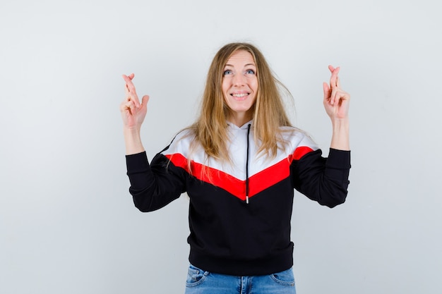 Joven mujer rubia en una chaqueta y jeans