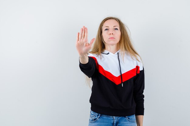 Joven mujer rubia en una chaqueta y jeans