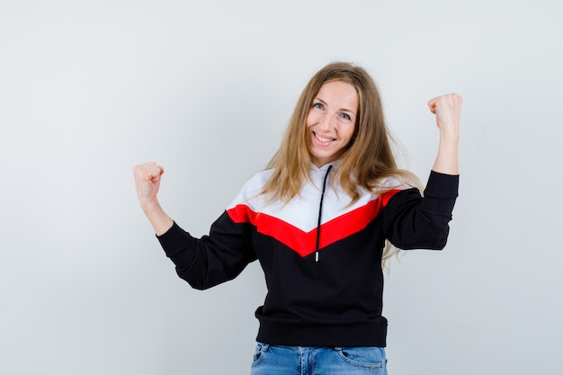 Joven mujer rubia en una chaqueta y jeans