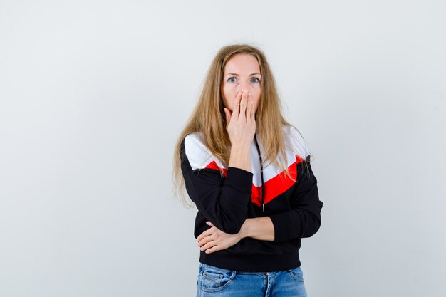 Joven mujer rubia en una chaqueta y jeans