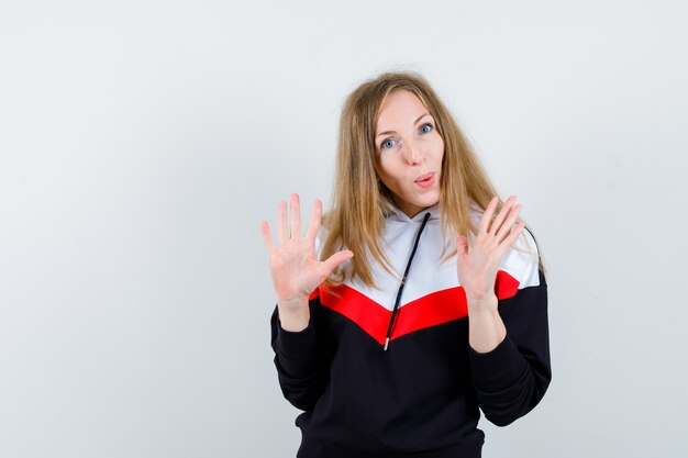 Joven mujer rubia en una chaqueta y jeans