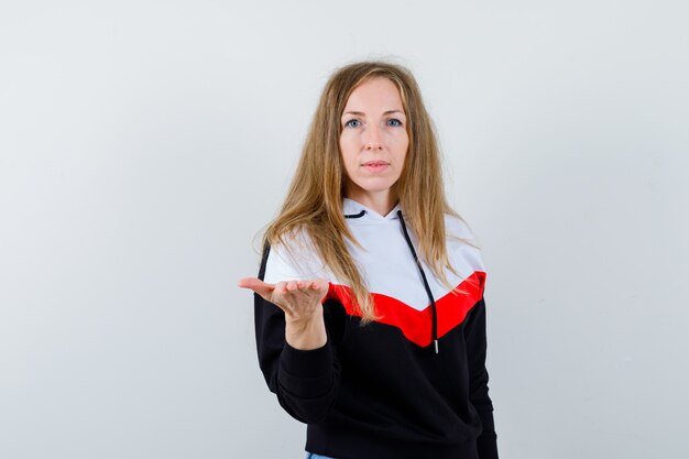 Joven mujer rubia en una chaqueta y jeans