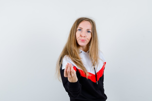 Joven mujer rubia en una chaqueta y jeans