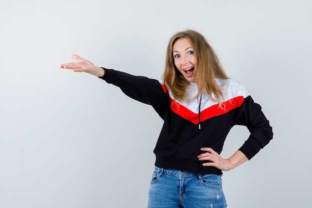 Joven mujer rubia en una chaqueta y jeans