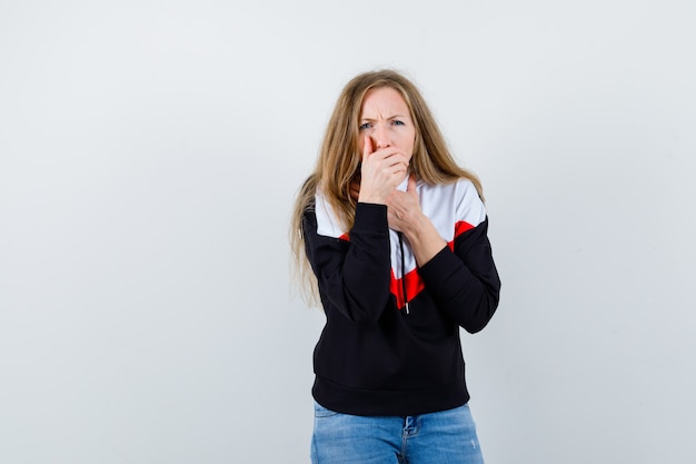 Joven mujer rubia en una chaqueta y jeans