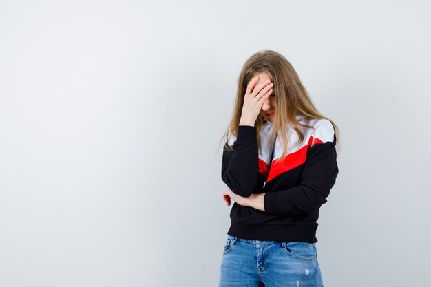 Joven mujer rubia en una chaqueta y jeans