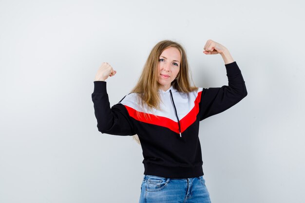 Joven mujer rubia en una chaqueta y jeans