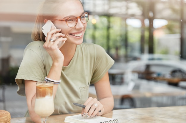 Joven mujer rubia con gafas en el café