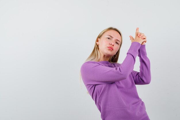 Joven mujer rubia con un suéter morado