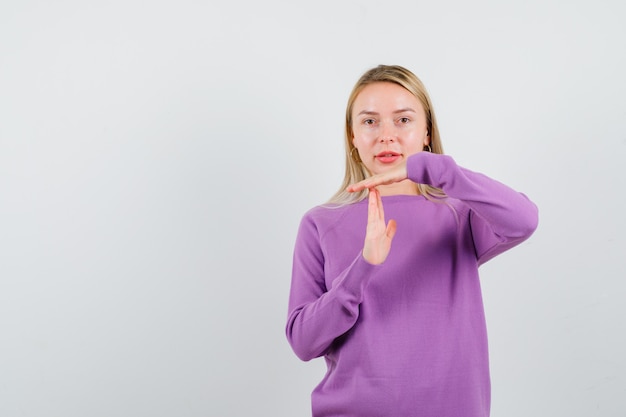 Joven mujer rubia con un suéter morado