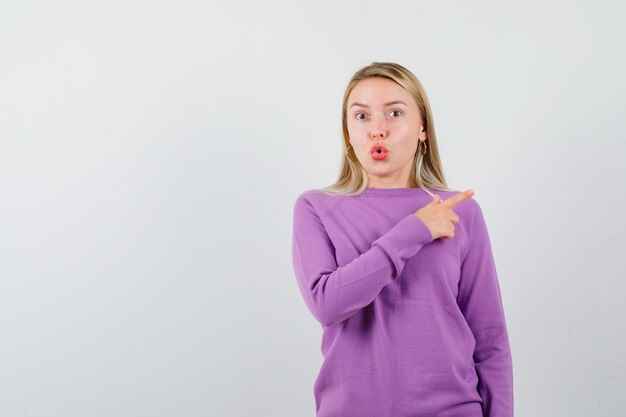 Joven mujer rubia con un suéter morado