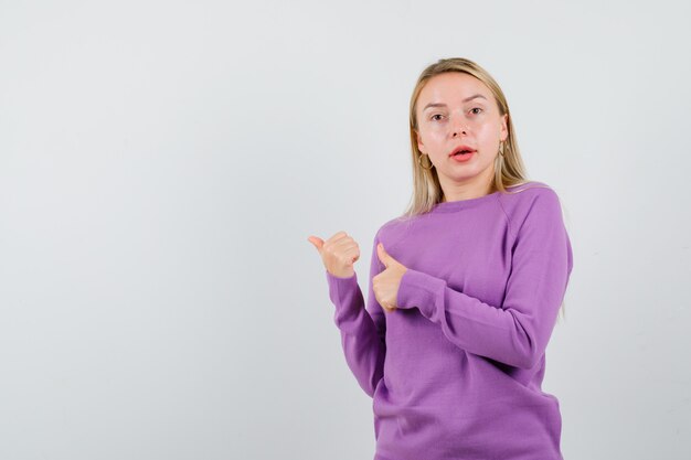 Joven mujer rubia con un suéter morado