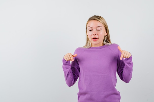 Joven mujer rubia con un suéter morado