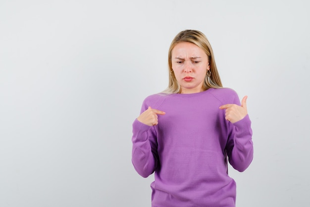 Joven mujer rubia con un suéter morado