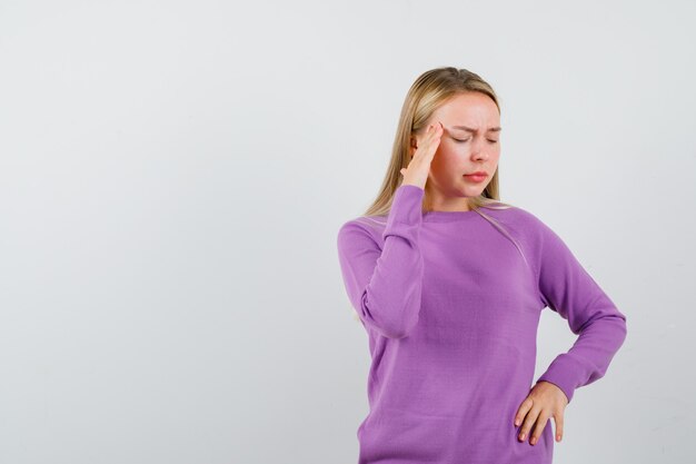 Joven mujer rubia con un suéter morado