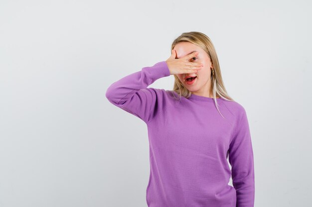 Joven mujer rubia con un suéter morado