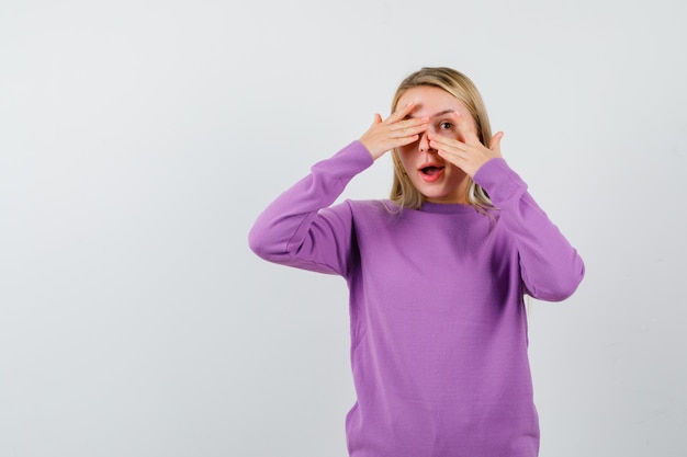 Joven mujer rubia con un suéter morado