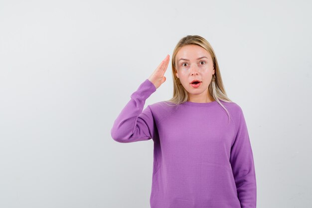 Joven mujer rubia con un suéter morado