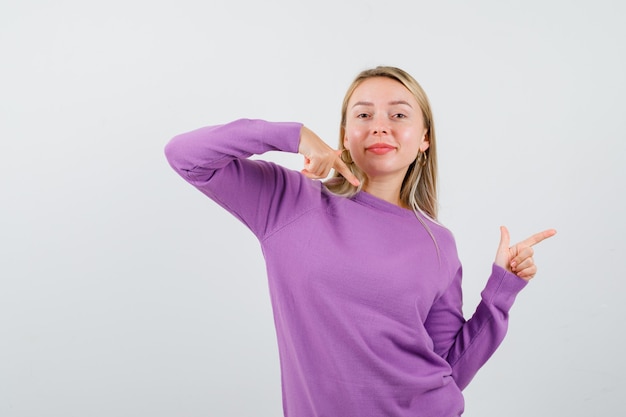 Joven mujer rubia con un suéter morado