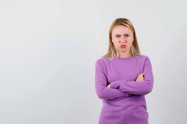 Joven mujer rubia con un suéter morado