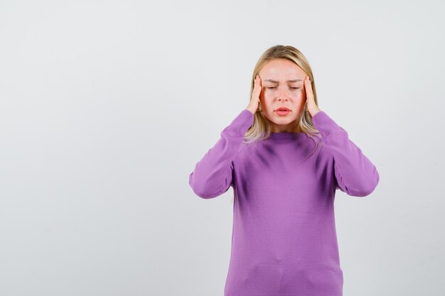 Joven mujer rubia con un suéter morado