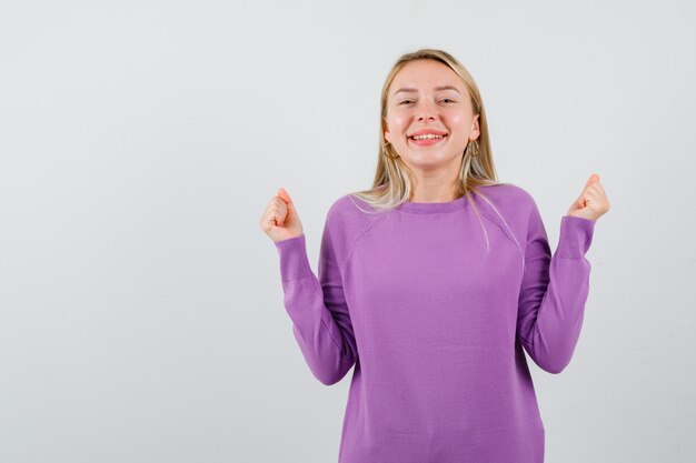 Joven mujer rubia con un suéter morado