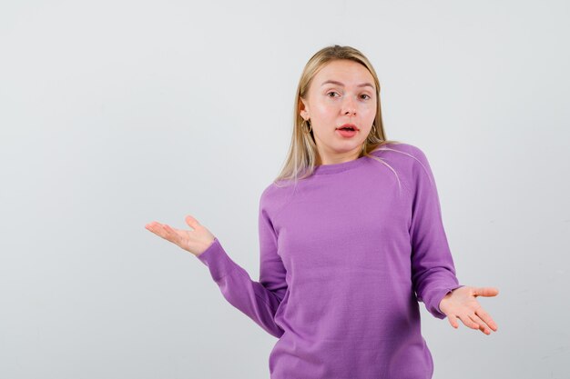 Joven mujer rubia con un suéter morado