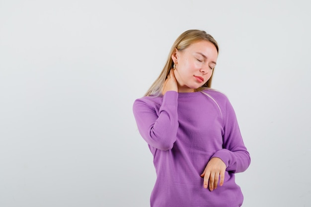 Joven mujer rubia con un suéter morado