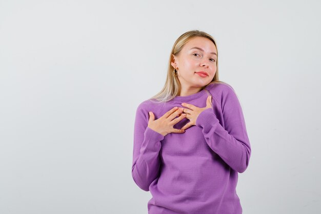 Joven mujer rubia con un suéter morado