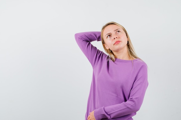 Joven mujer rubia con un suéter morado